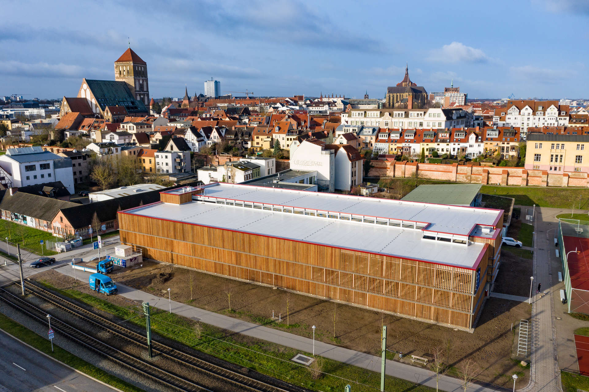 Luftbild vom Rostocker Parkhaus Altstadt, im Hintergrund die östliche Altstadt, die Marienkirche, das Hochhaus in der August-Bebel-Straße und die Nikolai-Kirche, im Vordergrund Straßenbahnschienen und die Straße Küterbruch