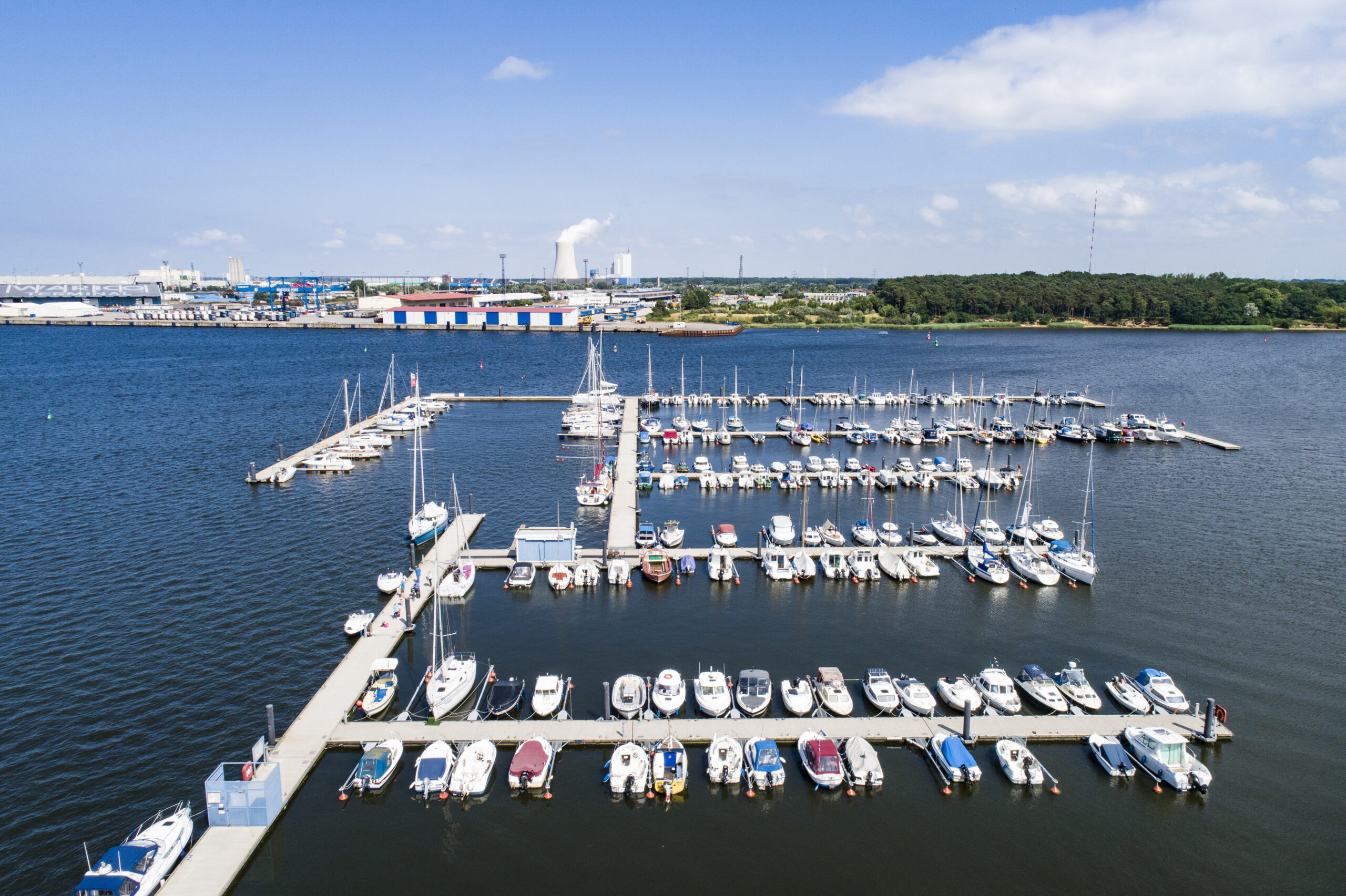 Luftbild aus flachem Winkel auf die Marina und Schwimmsteganlage in Rostock Schmarl an der Warnow im Hintergrund das Rostocker Kraftwerk und die Fähranleger des Überseehafens