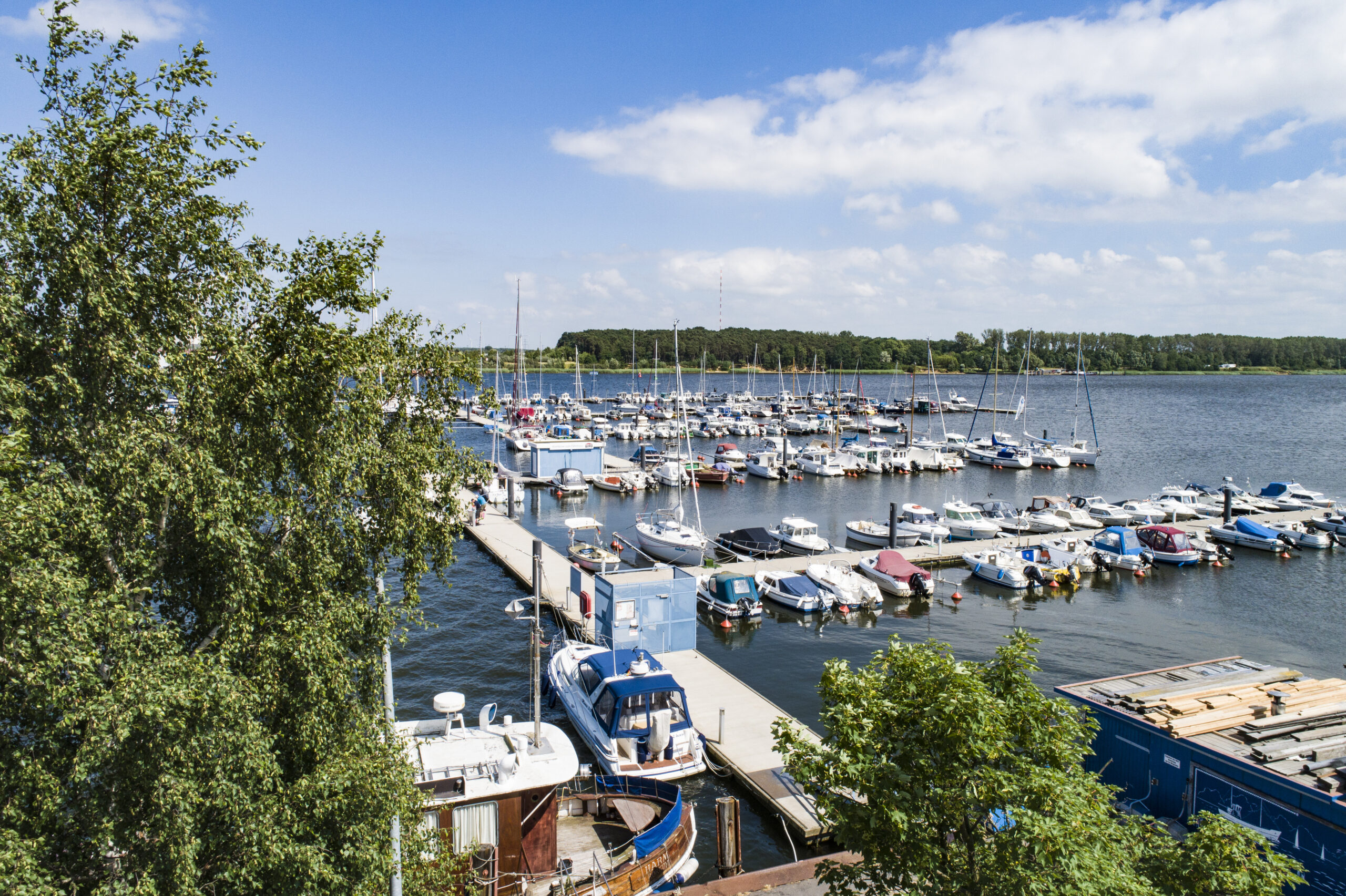 Luftbild aus flachem Winkel auf die Marina und Schwimmsteganlage in Rostock Schmarl an der Warnow im Hintergrund das östliche Ufer der Warnow