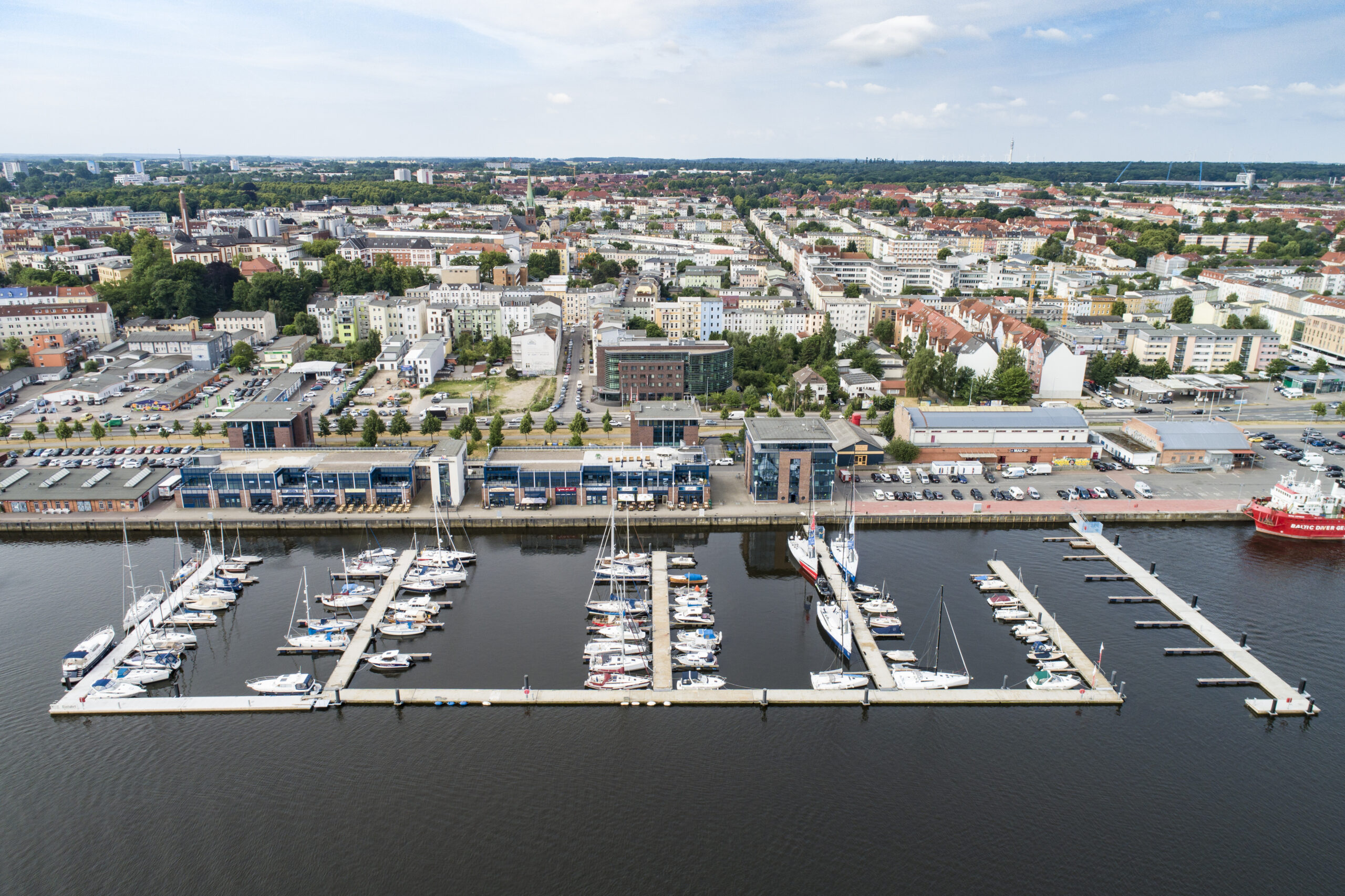 Luftbild mit Blick Richtung Süden auf die Schwimmsteganlage und Marina Rostocker Stadthafen im Hintergrund der Gebäudekomplex Hafenterrassen und der Stadtteil KTV